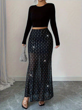 Jupe mi-longue moulante taille haute en maille transparente ornée de strass argentés scintillants