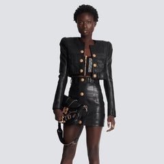 Ritzy – Kurze Bikerjacke aus veganem Leder mit goldenen Knöpfen und Schulterpolstern, langen Ärmeln